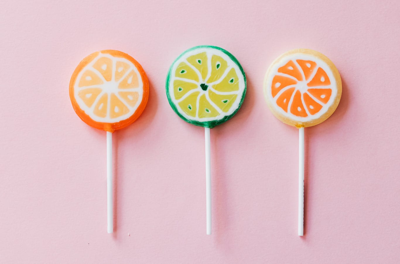 social media best practices blog header image. pink background with three citrus lollipops for decoration